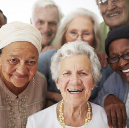 A group of seniors smiling together while in a retirement home